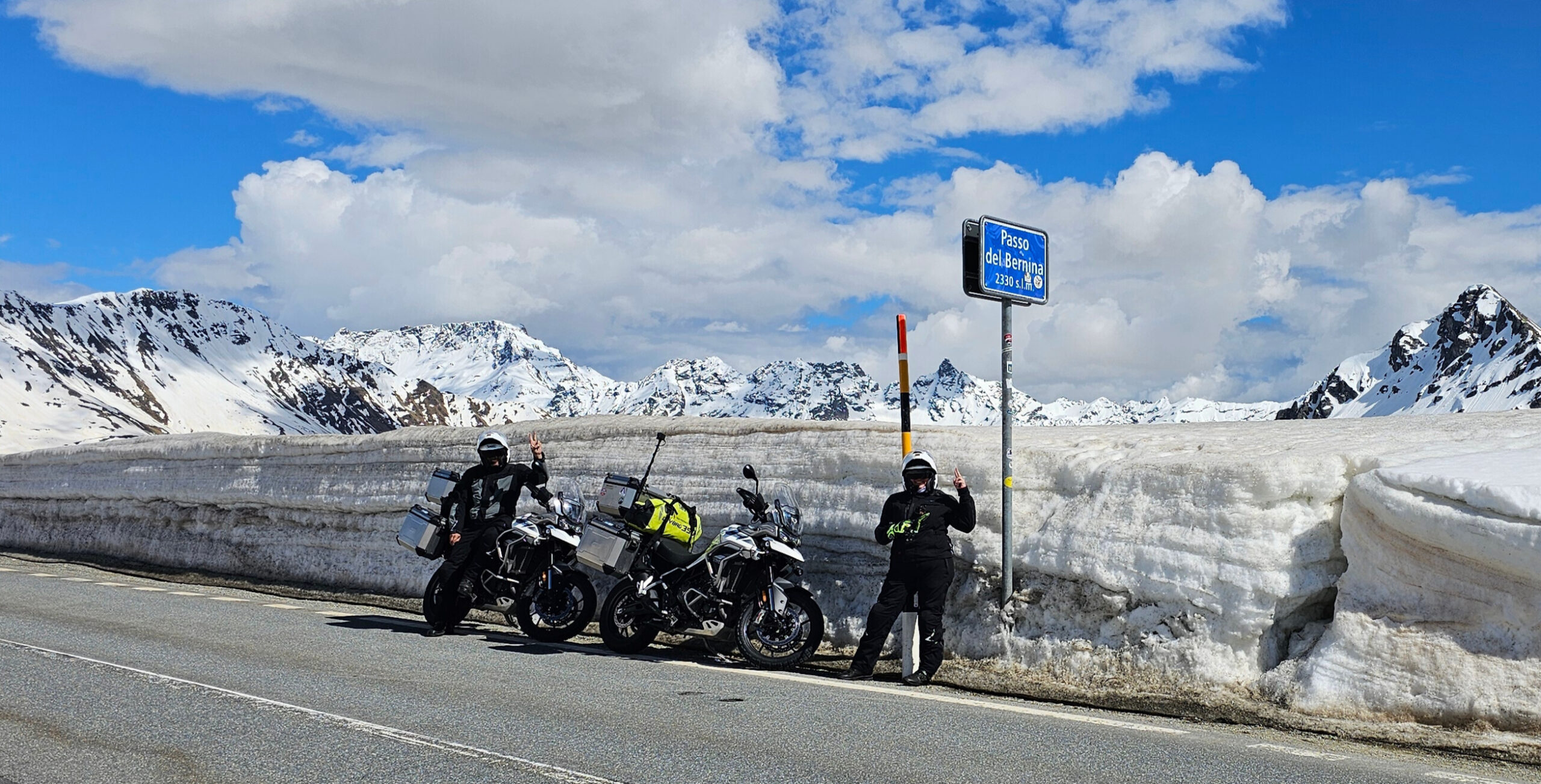 Au sommet du Passo del Bernina, deux motards affrontent encore la neige d’altitude, entourés d’un paysage grandiose où la route défie les sommets enneigés des Alpes