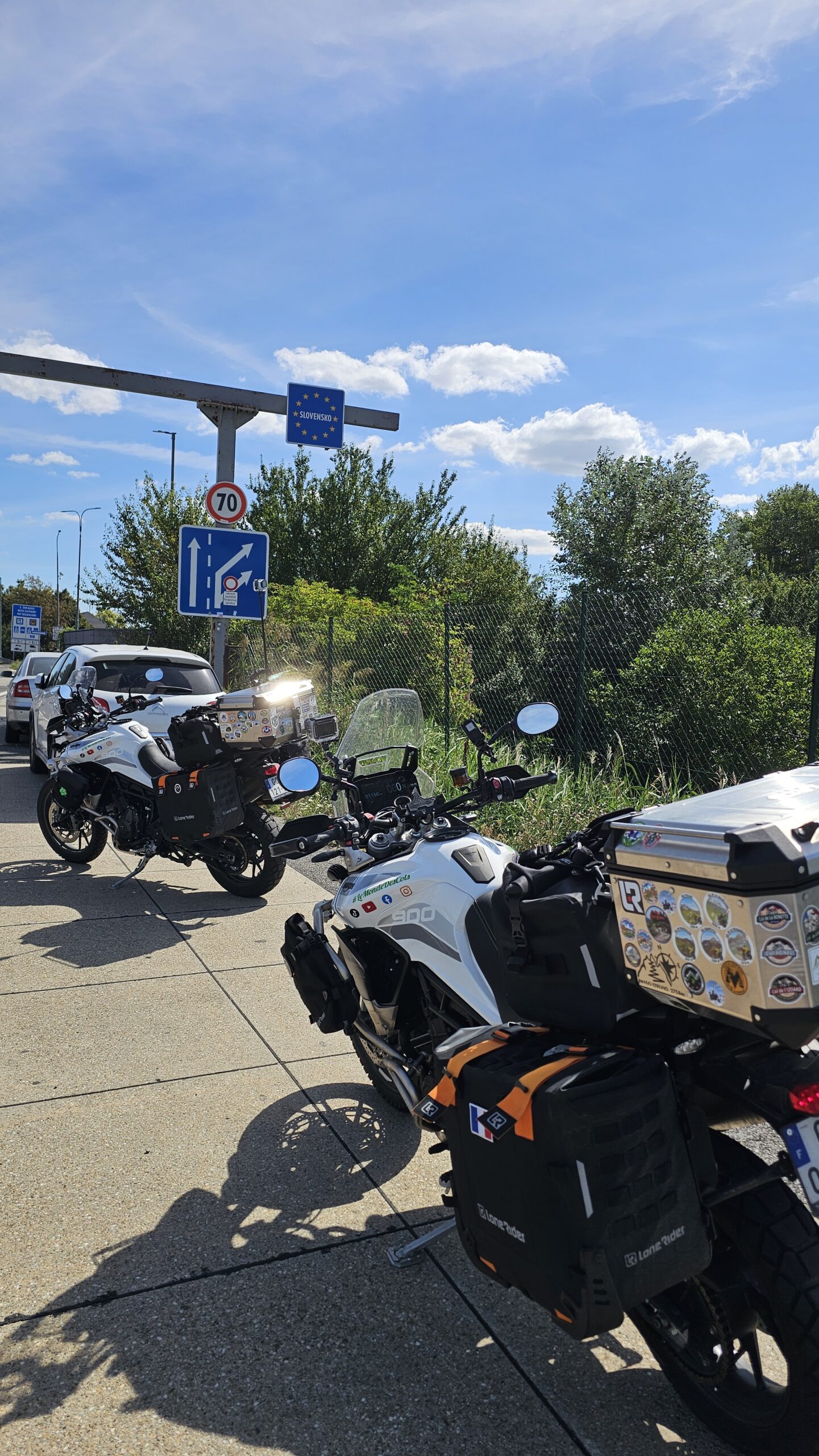 Photo de nos motos garées sous le panneau “Slovensko”, marquant l’entrée en Slovaquie lors de notre roadtrip à moto.