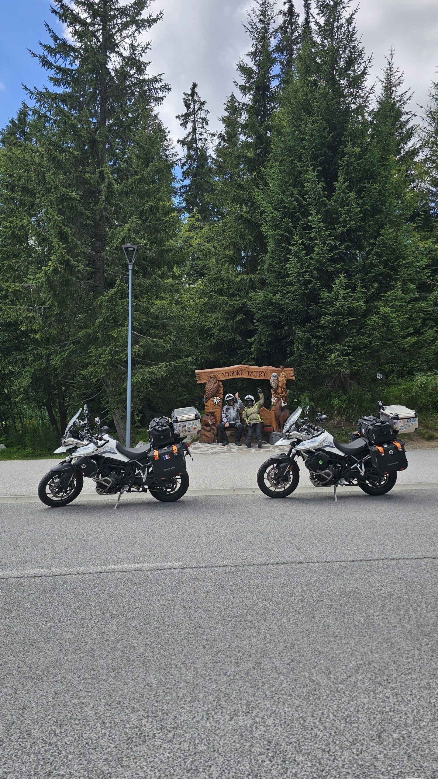 Photo de nous assis sur une grande sculpture en bois dans le parc national des Hautes Tatras, en Slovaquie.
