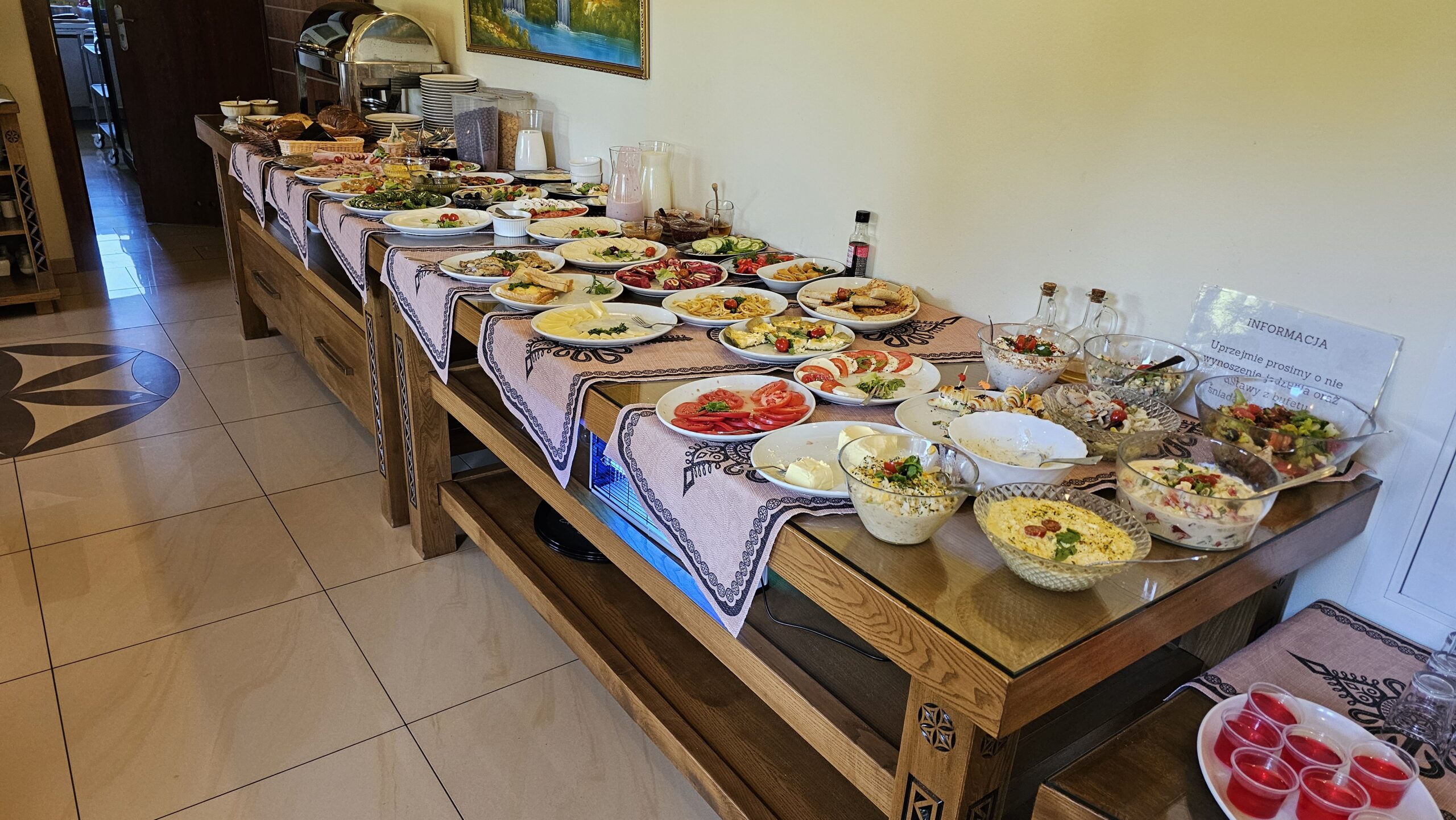 Photo d’un buffet de petit-déjeuner en Pologne, garni de plats salés, charcuteries, fromages, pains et fruits frais.