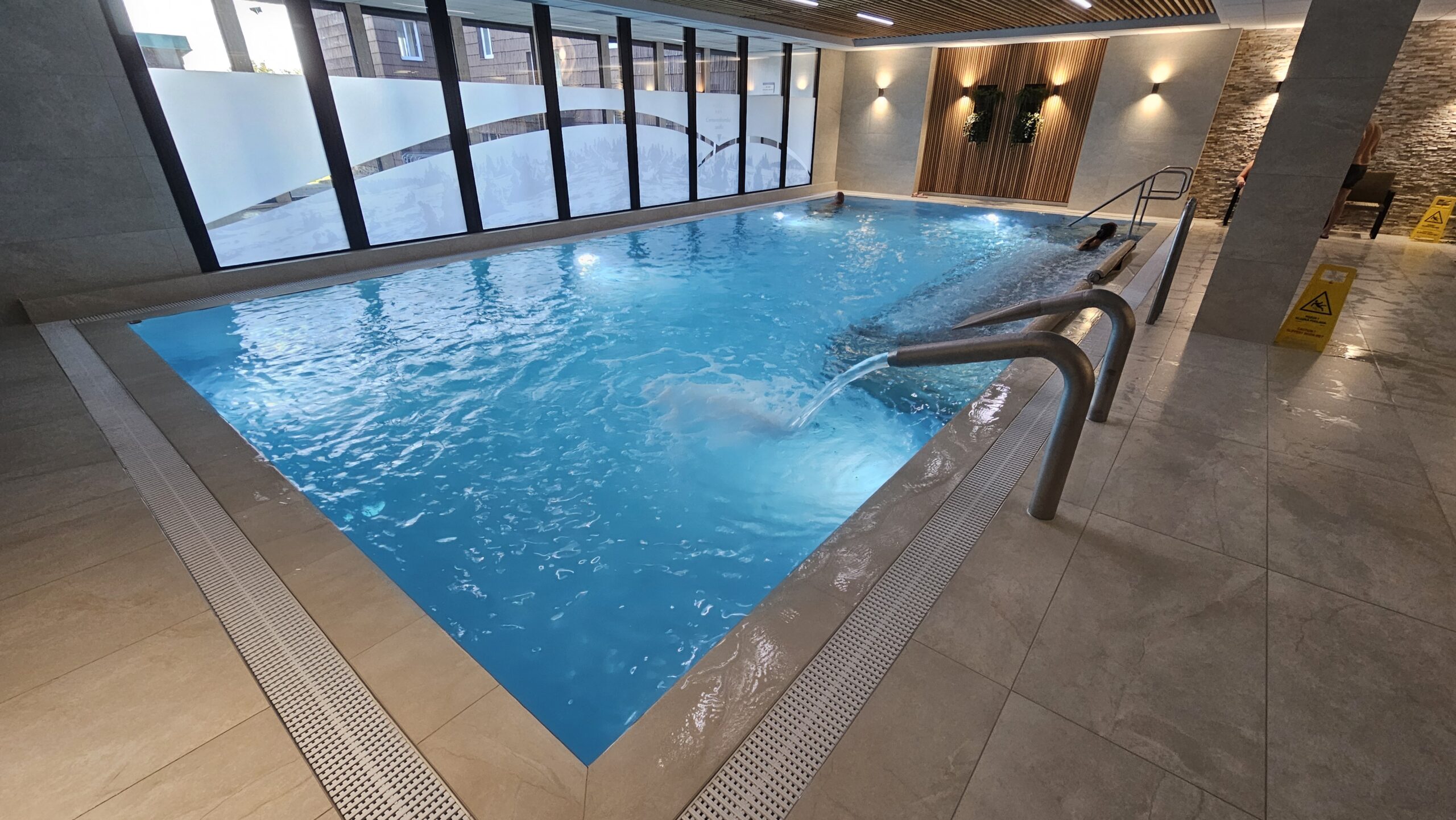 Piscine intérieure avec jets spa dans un hôtel de montagne, symbole de détente après une longue journée à moto.