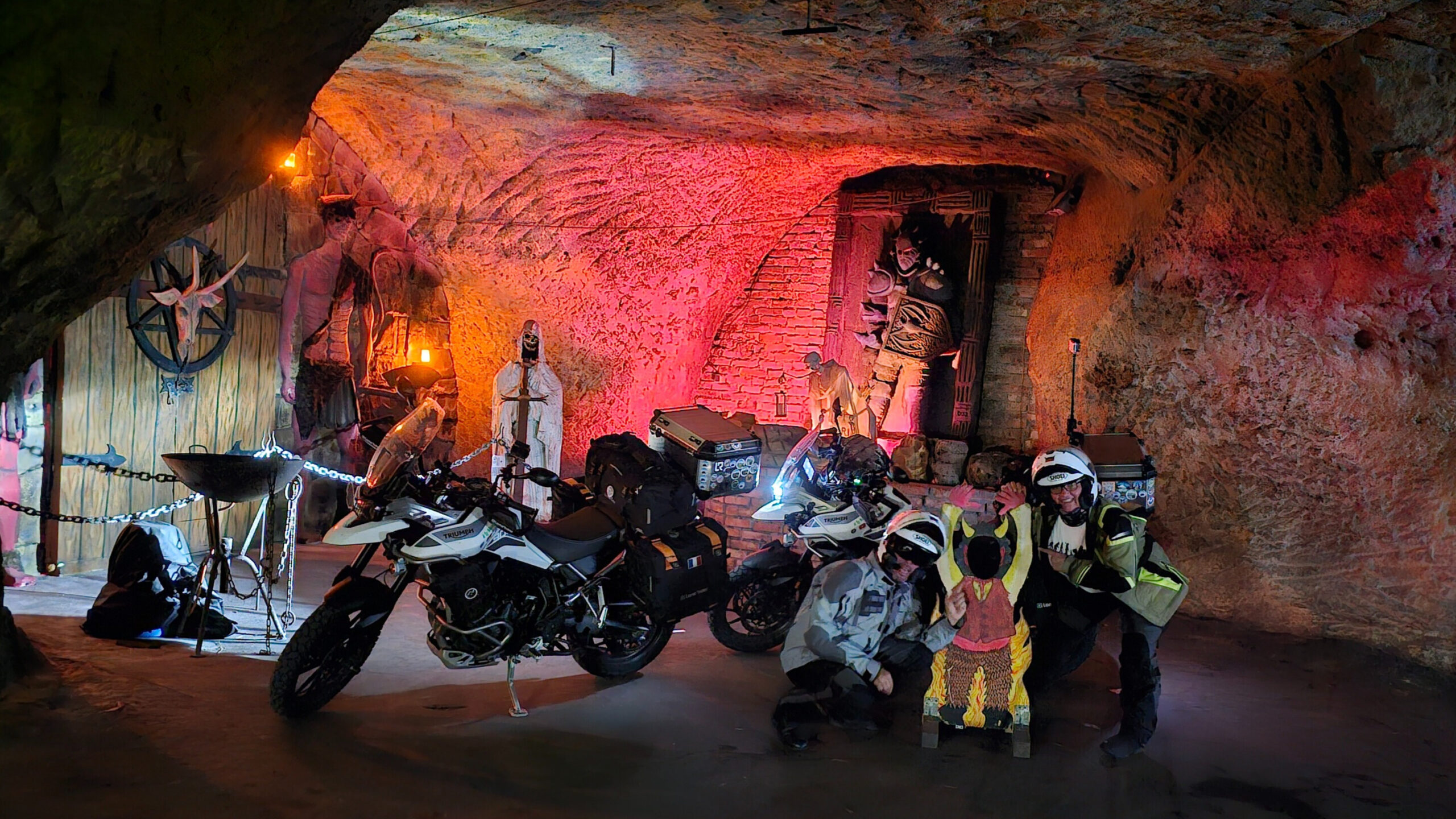 Photo prise à l’intérieur des Grottes de l’Enfer en République tchèque, montrant une cavité décorée de sculptures sombres et d’un diablotin.