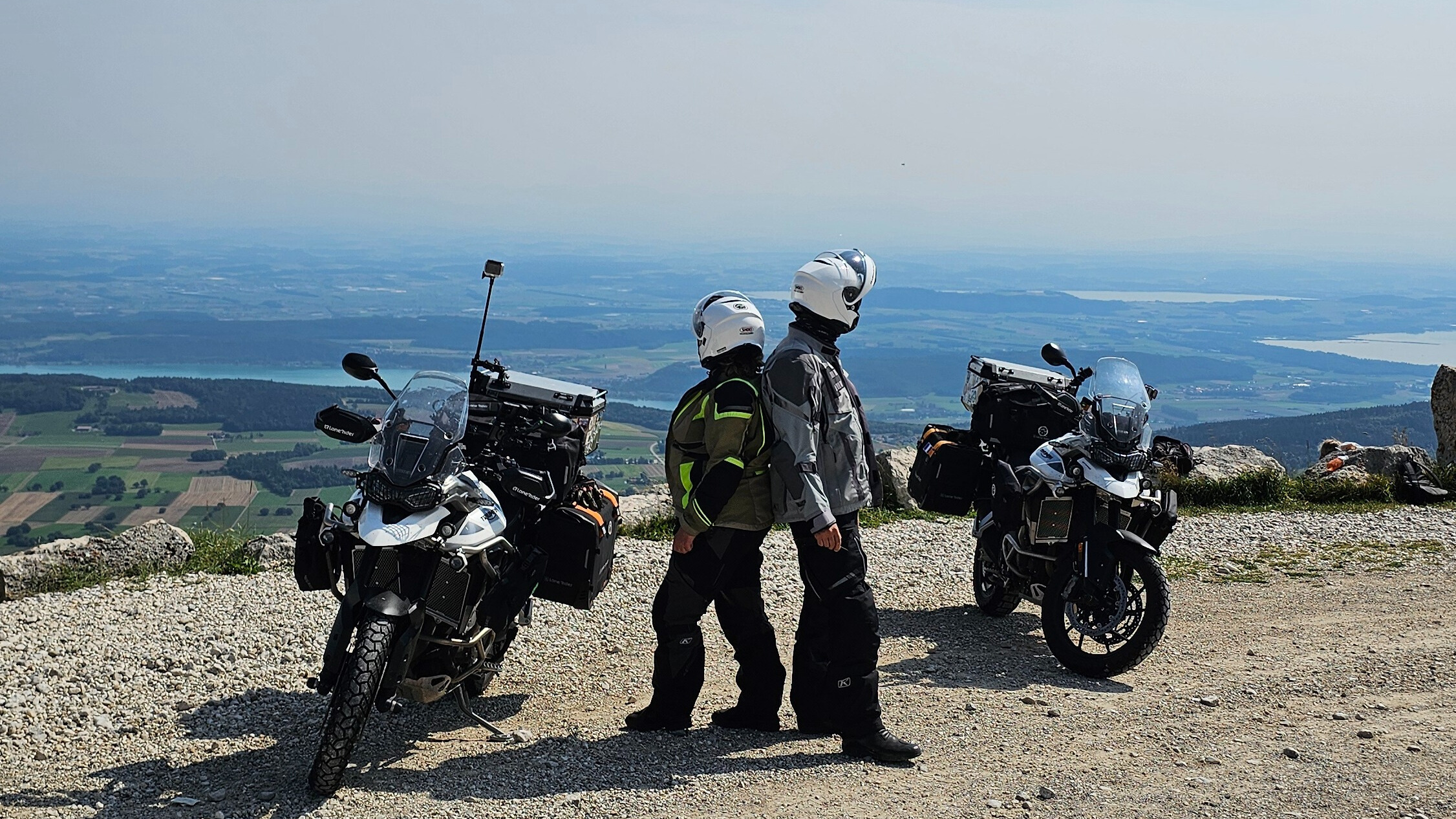 Vue depuis le col du Chasseral en Suisse, après le panneau, révélant un panorama féérique sur les lacs et les vallées du Jura bernois.