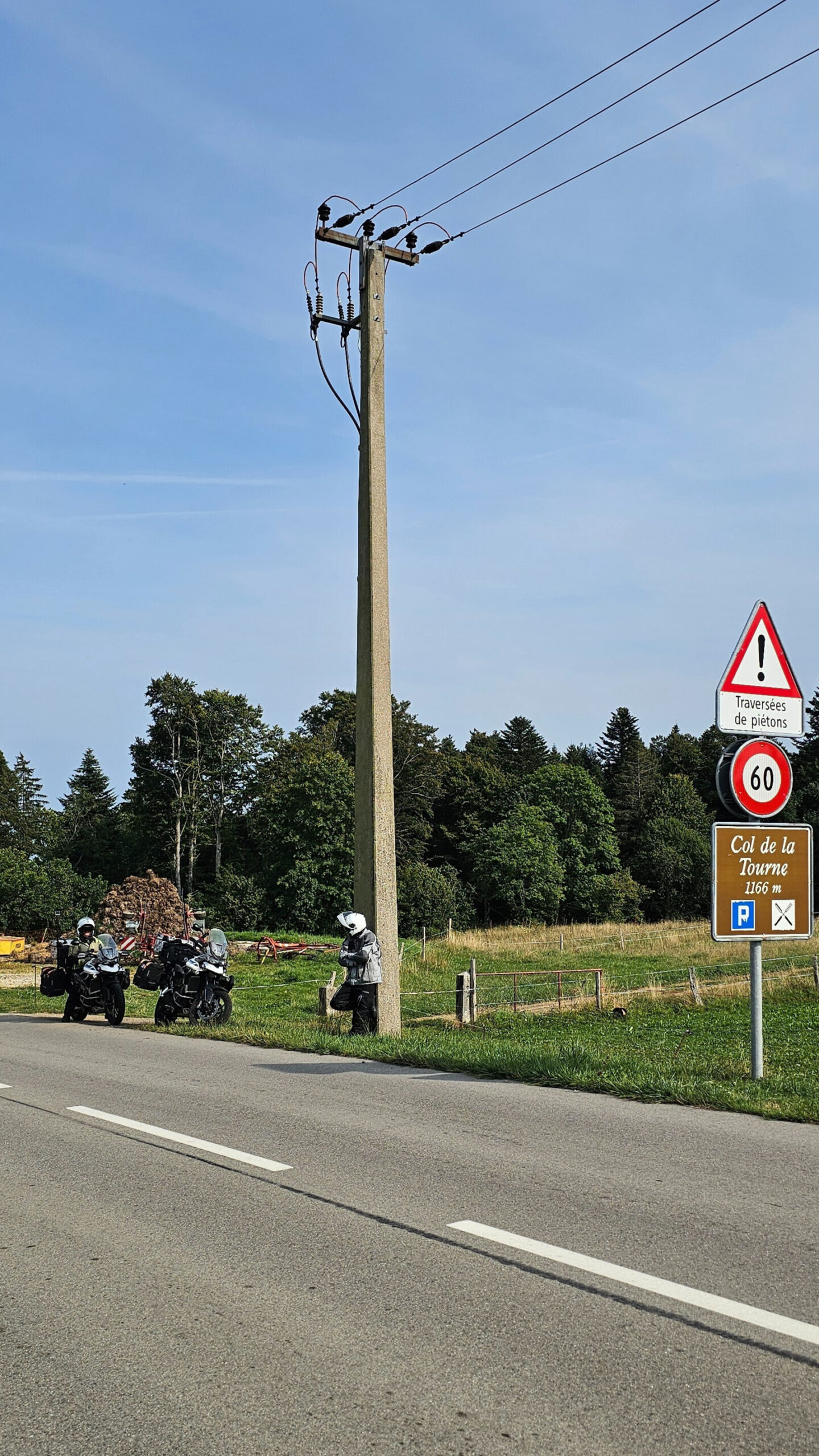 Nos motos au col de la Tourne, route forestière du Jura neuchâtelois reliant Noiraigue à La Vue-des-Alpes, baignée d’une lumière dorée.