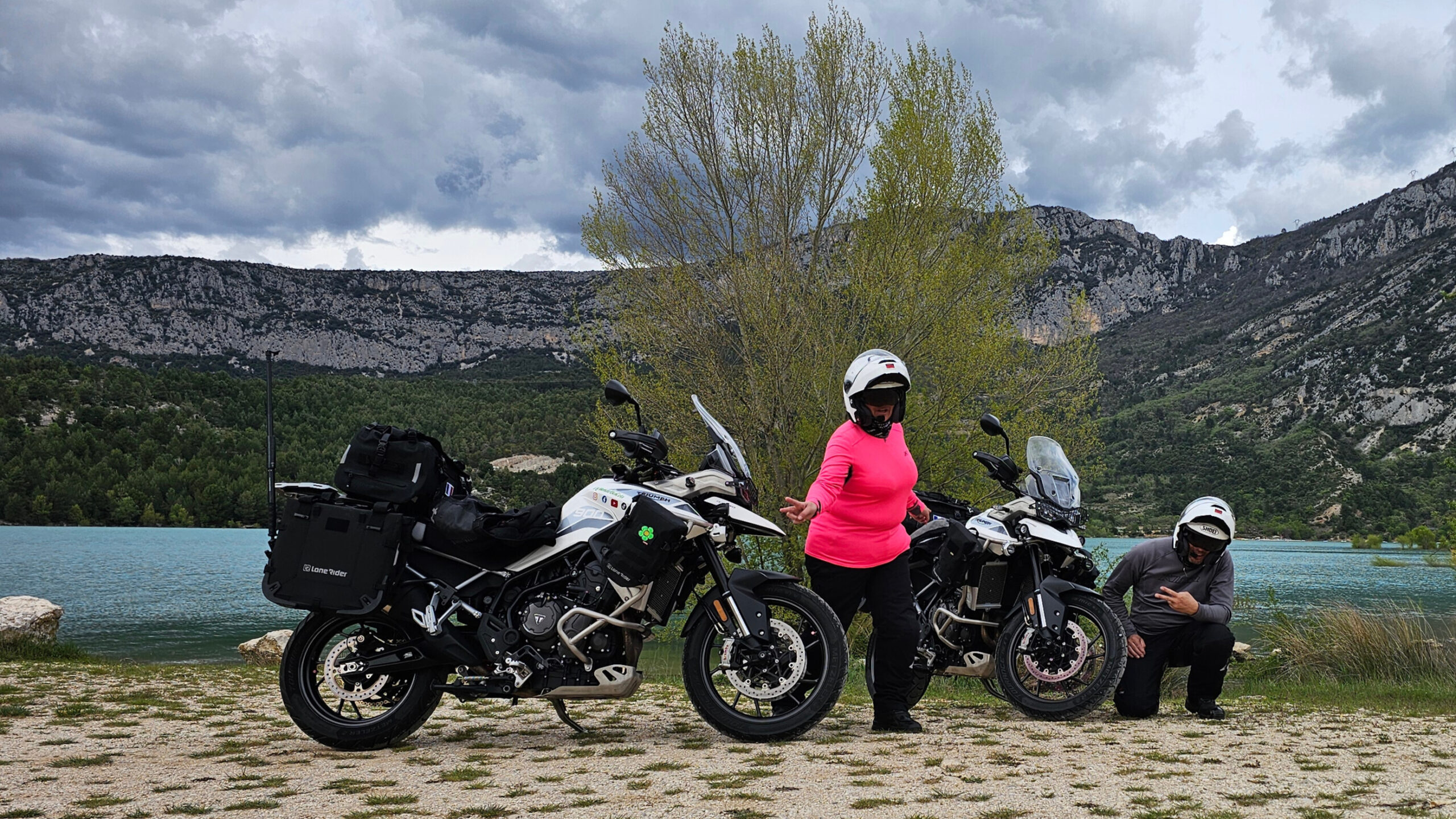 Motos équipées d’une perche à selfie GoPro au bord du lac dans les gorges du Verdon, roues presque dans l’eau, avec les motards au milieu des machines.