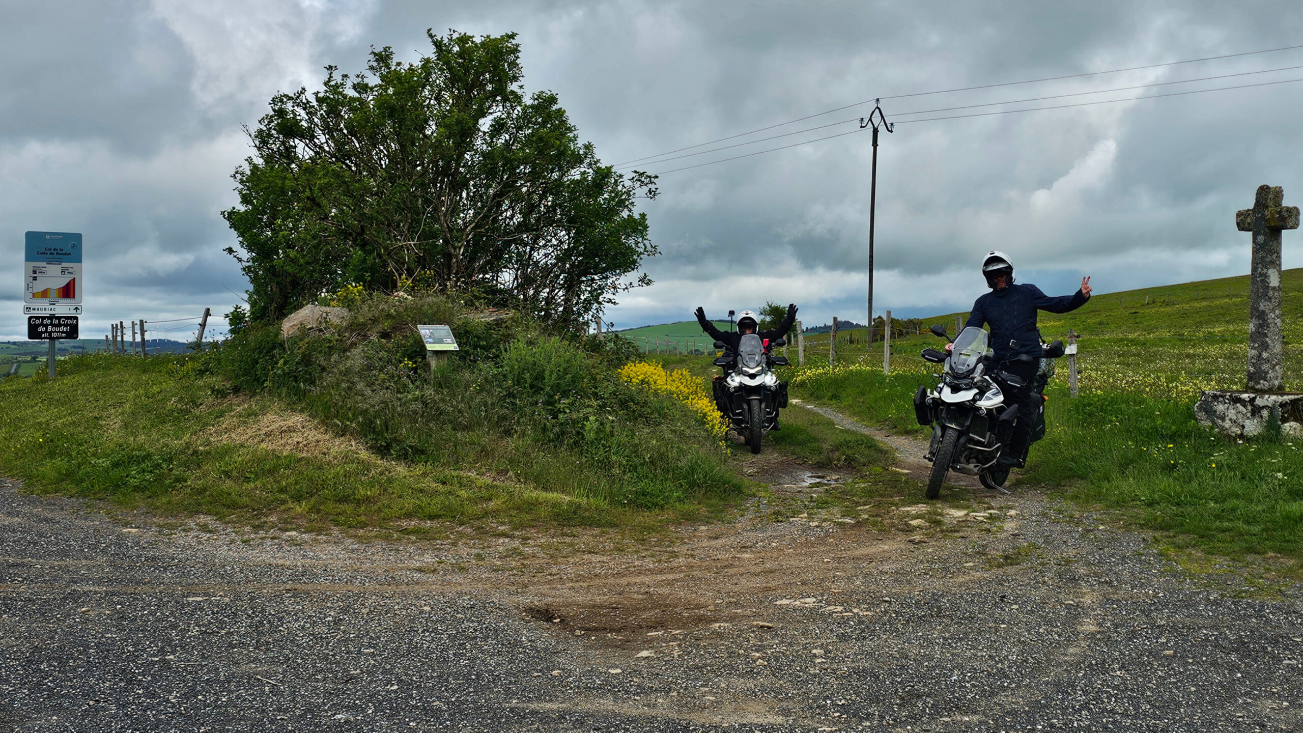 Panneau du Col de la Croix de Boudet avec la croix, la route et un chemin offroad dans les reliefs de l'Aveyron