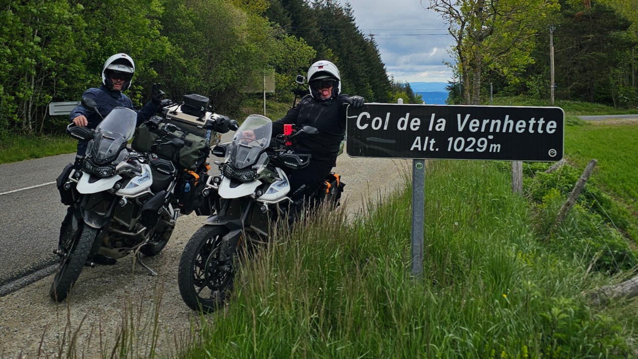 Deux motos Triumph garées à côté du panneau officiel du Col de Vernhette (1029 m) dans l'Aveyron.