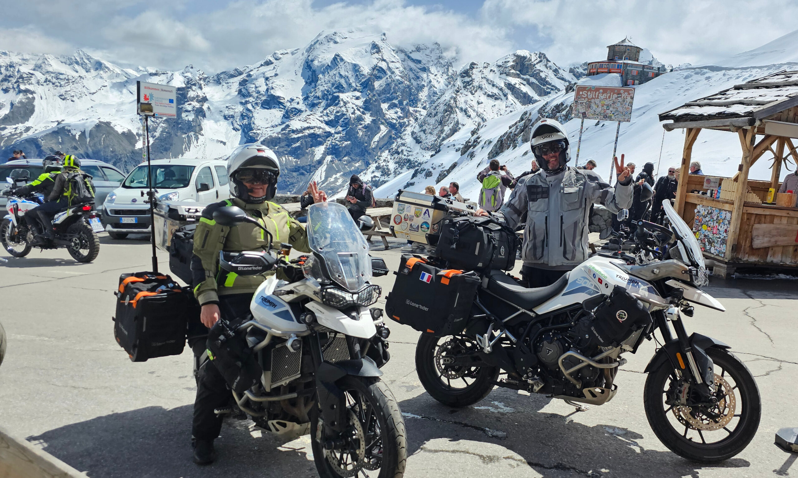 Le panneau officiel du Passo dello Stelvio recouvert de stickers de clubs moto et le glacier en fond