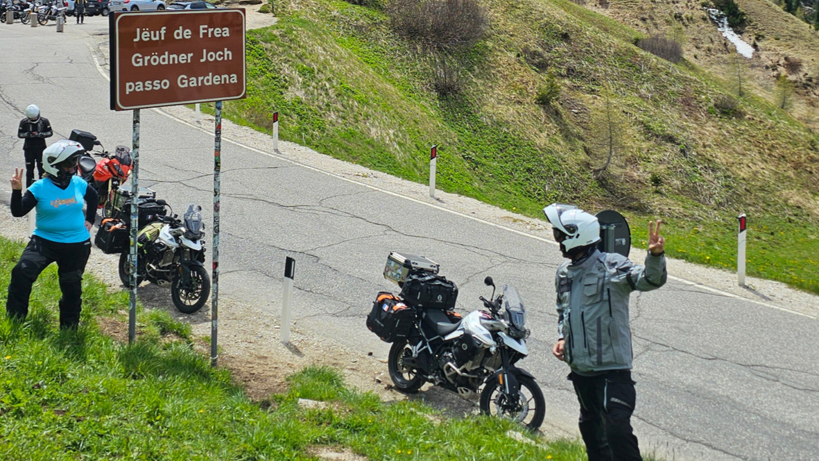 Vue en contrebas et en plongée sur les panneaux de signalisation du Passo Gardena installés sur la bande cyclable.