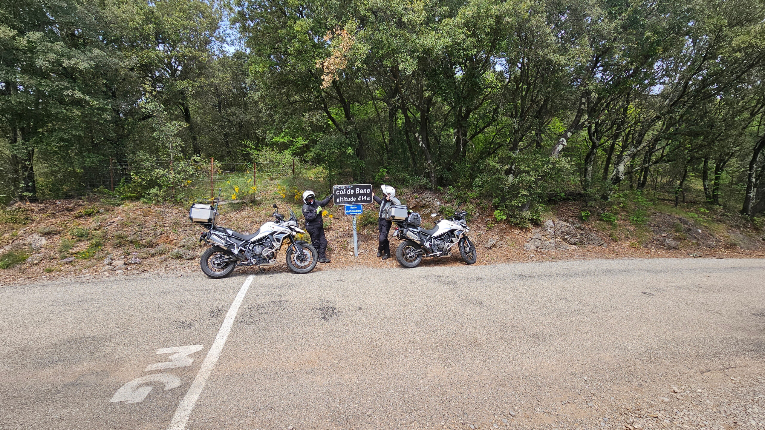 Vue grand angle sur le ruban d'asphalte du Col de Bane et les motos équipées
