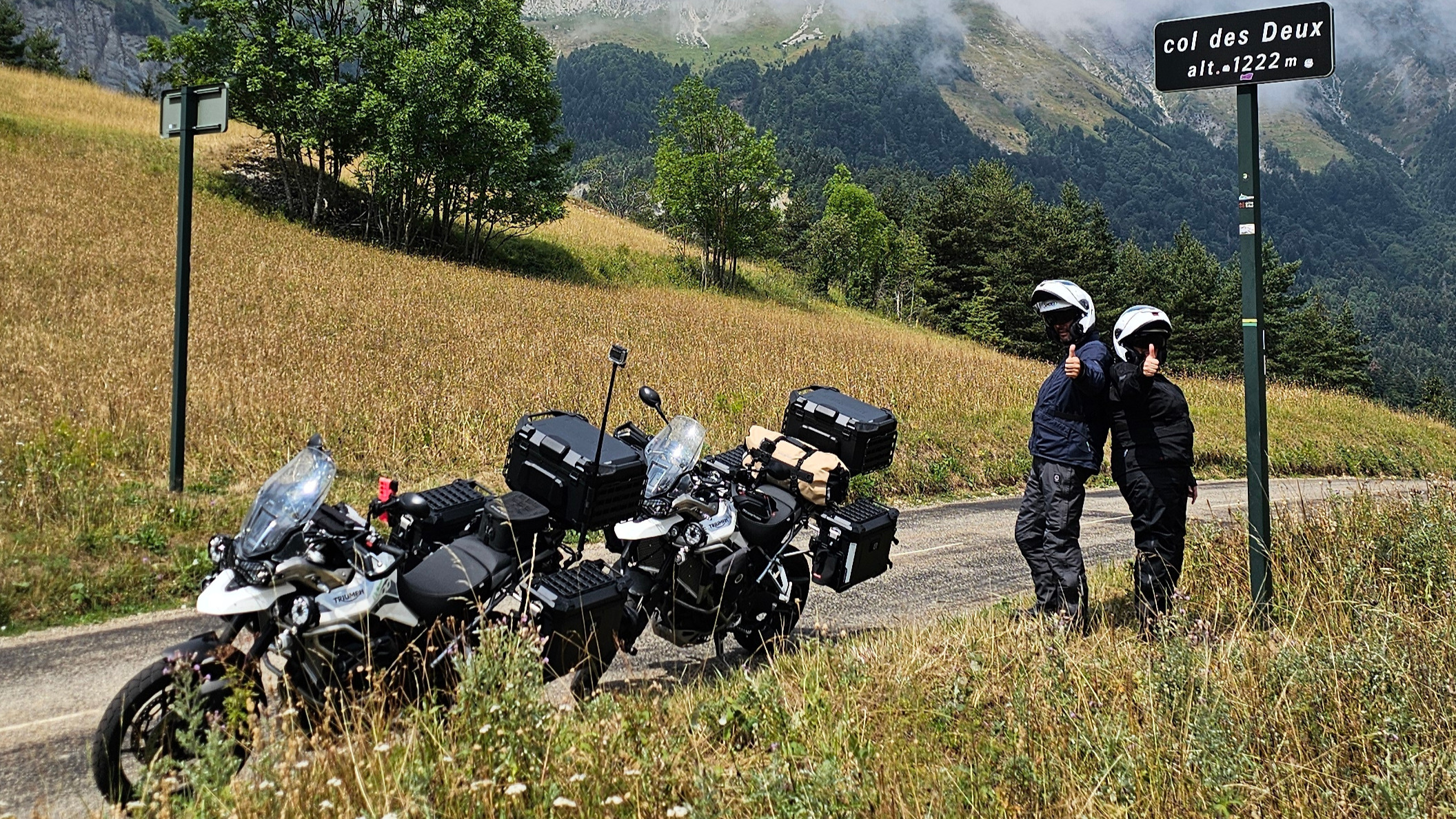 Clin d'œil au panneau du Col des Deux avec deux pouces levés symbolisant le chiffre deux face au panorama du Vercors.