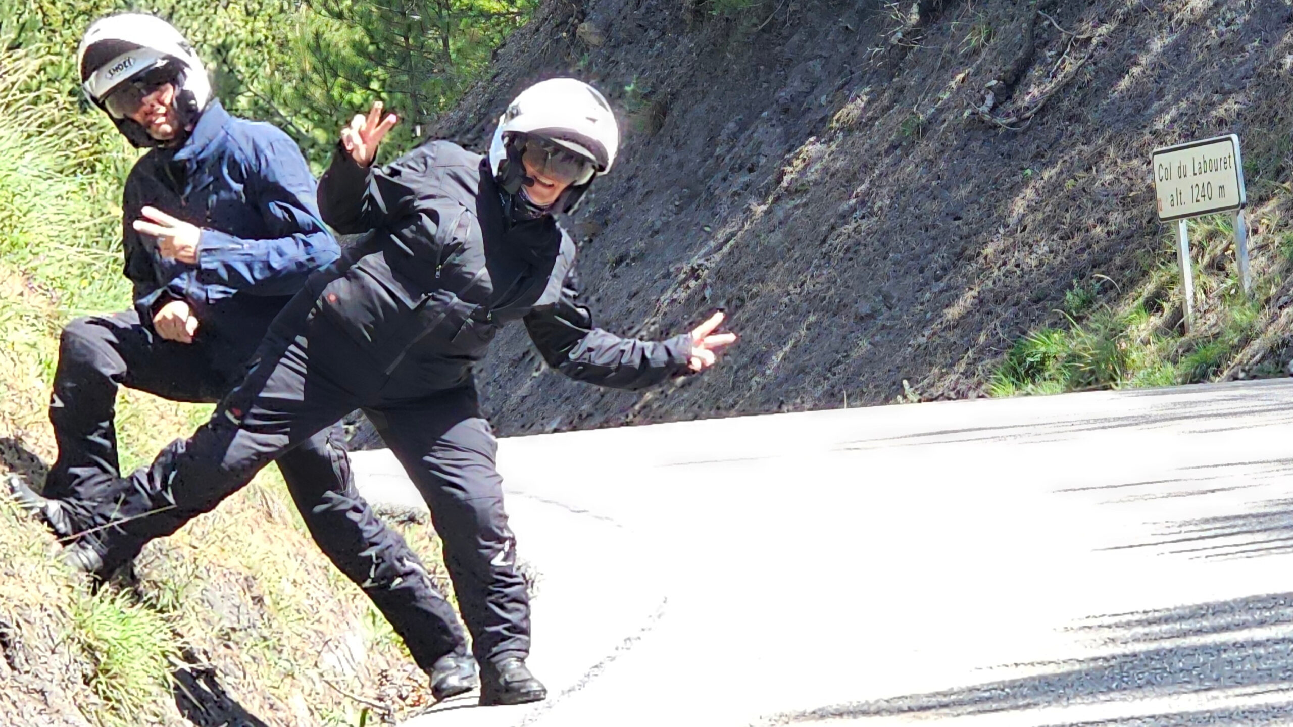 Panorama sur la route du col du Labouret avec motard en équipement Halvarssons et le panneau gris.