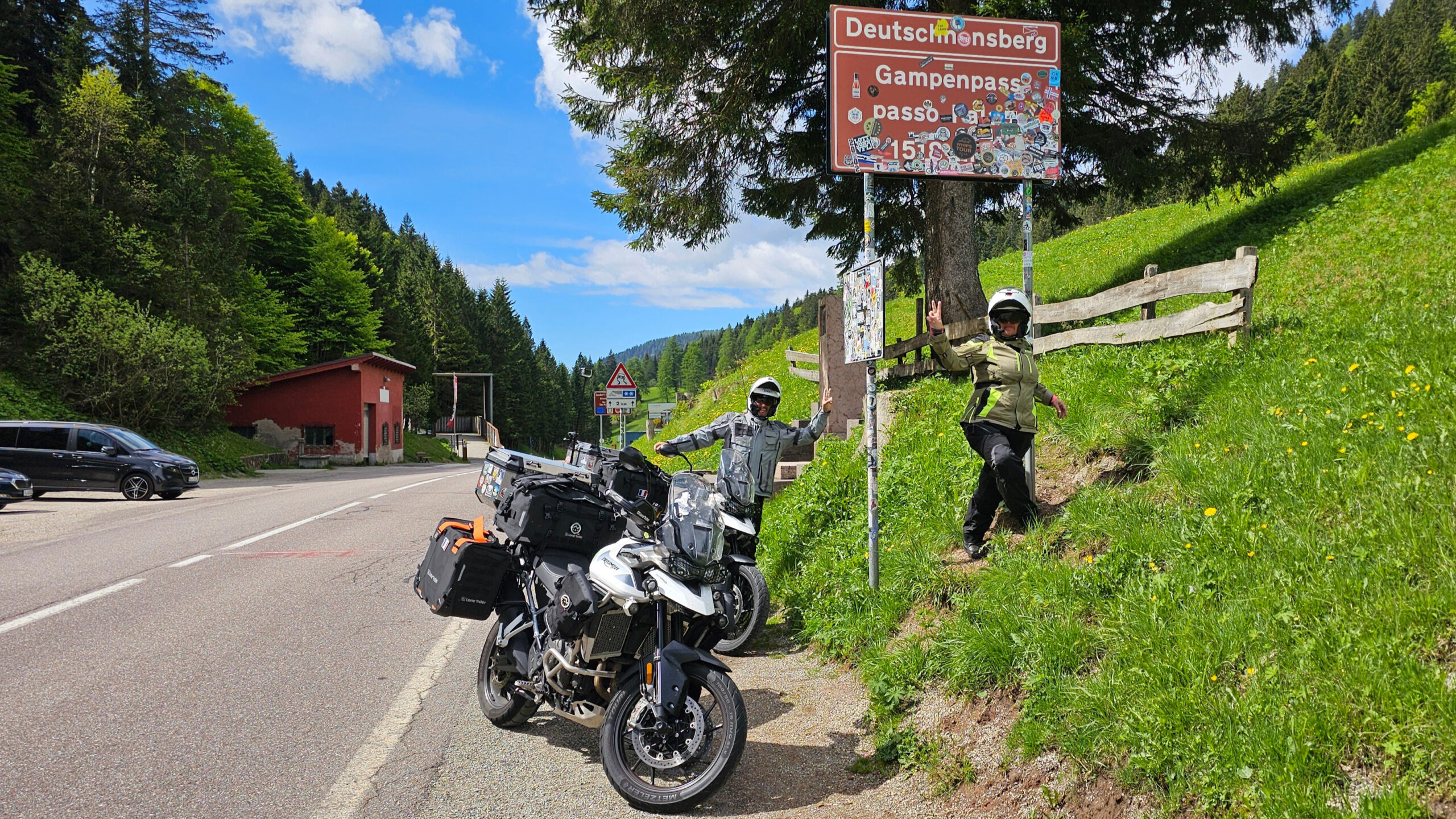 Panneau officiel du Passo delle Palade entouré d'herbe verte avec vue sur la route